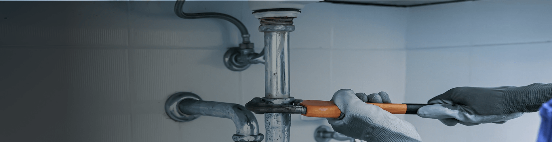 Maintenance Worker Doing Plumbing Work Under a Sink-1